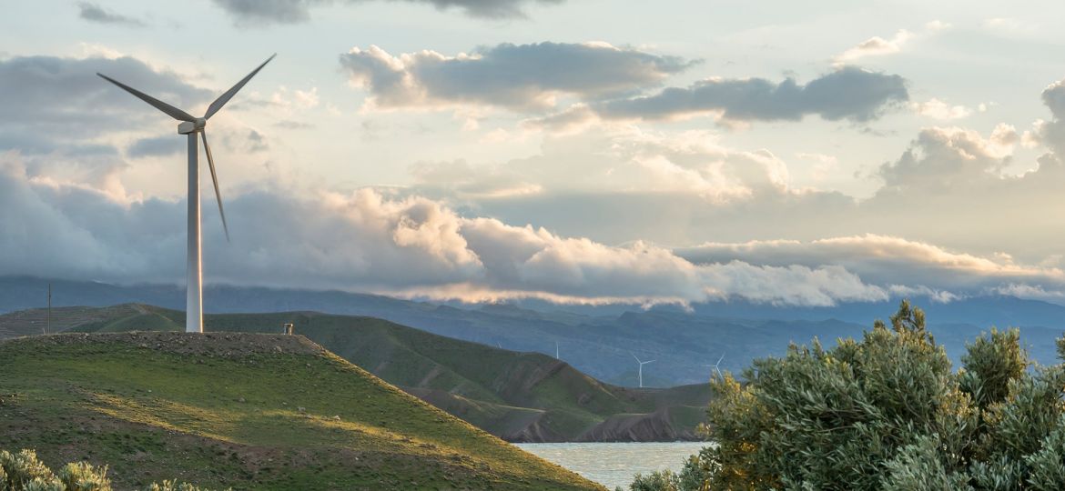 wind-power-turbine-hill-front-cloudy-sky